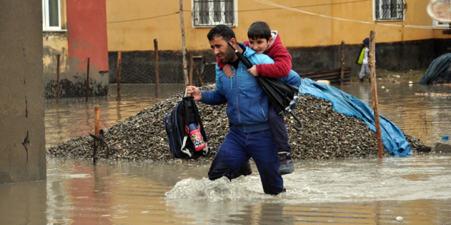 Veliler, öğrencileri sırtlarında taşıyarak okula götürdü