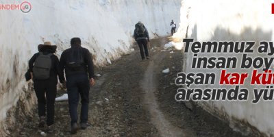 Temmuz ayında insan boyunu aşan kar kütleleri arasında yürüyüş