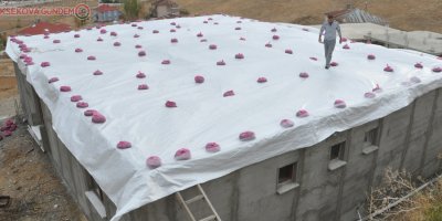 Poşetlere doldurduğu kumla kışa karşı önlem alıyor