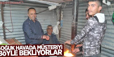 Soğuk havaya karşı soba yakarak müşteri bekliyorlar