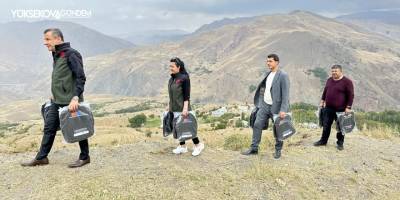 Yüksekova'da 2 bin rakımda yürüyerek öğrencilere okul çantası ulaştırdılar